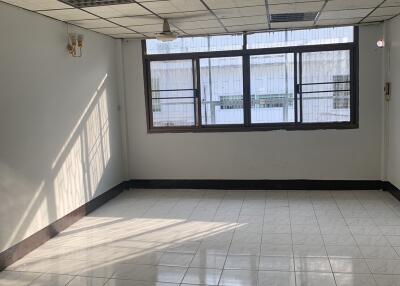 Well-lit empty room with tiled floor, large windows, and ceiling fan