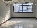 Spacious empty room with tiled floor and large windows