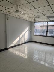 Spacious empty room with window and tiled flooring