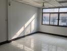 Spacious empty room with window and tiled flooring