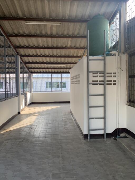 covered outdoor space with tiled floor and water tank