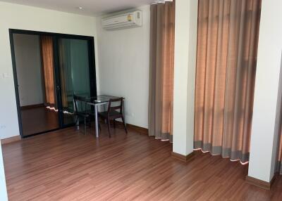 Modern living area with wooden flooring and large window