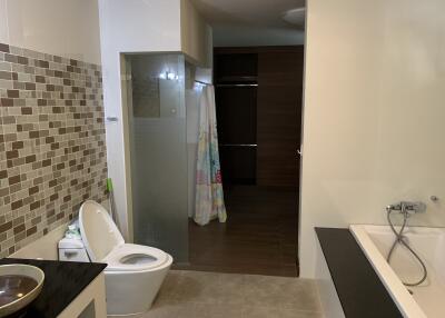 Modern bathroom with tile backsplash, glass shower, and bathtub