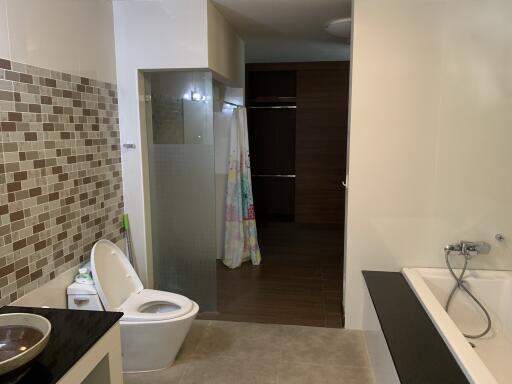 Modern bathroom with tile backsplash, glass shower, and bathtub