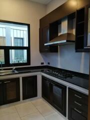 Modern kitchen with dark wooden cabinets and black countertops