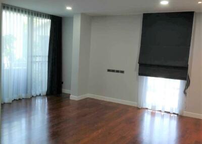 spacious living room with wooden flooring and large windows