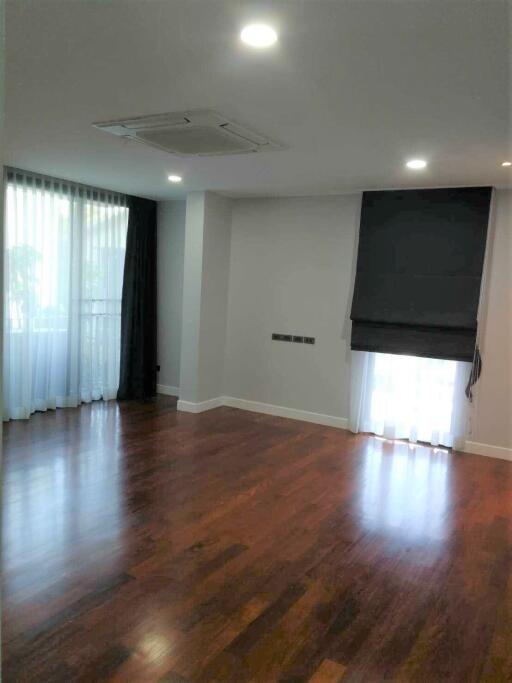 spacious living room with wooden flooring and large windows