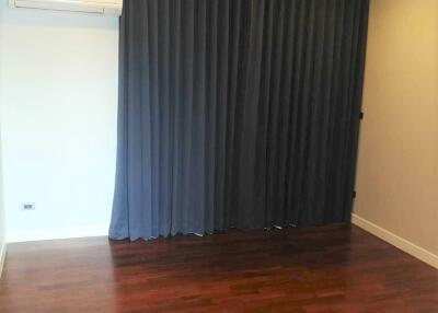 Bedroom with hardwood floors and dark curtains