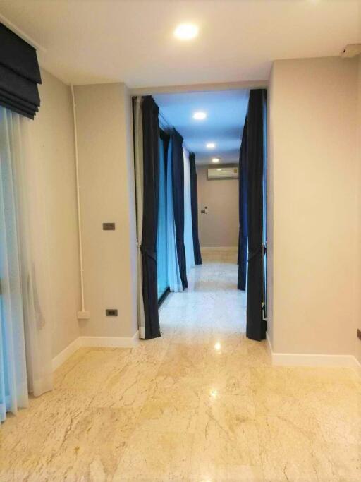 Bright hallway with marble floor and blue curtains