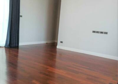 Empty living room with wooden floor, air conditioner, and large window with curtains