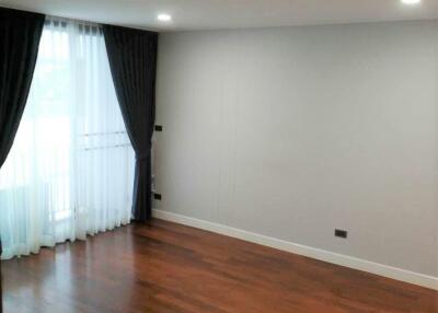 Empty bedroom with wooden flooring and large window