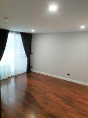 Empty bedroom with wooden flooring and large window