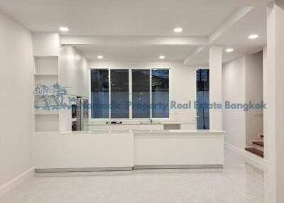 Modern white kitchen with built-in shelves and recessed lighting