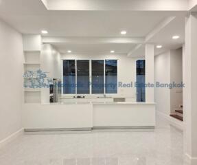 Modern white kitchen with built-in shelves and recessed lighting