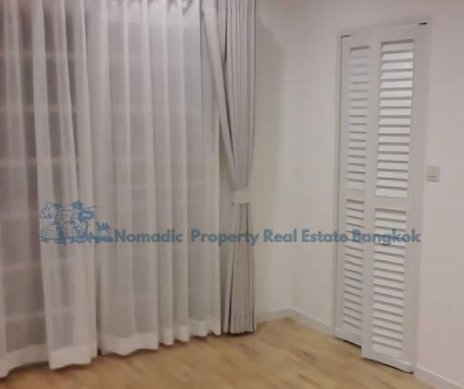 Bedroom with wooden floor and white curtains