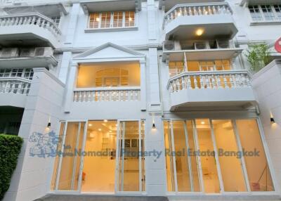 Front view of a multi-story residential building with glass doors