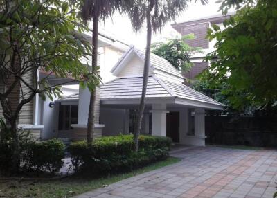 Front exterior view of the house showing driveway and greenery