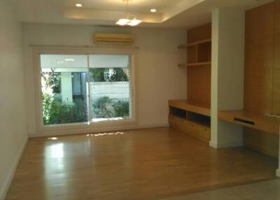 Bright and spacious living room with large window and built-in shelves