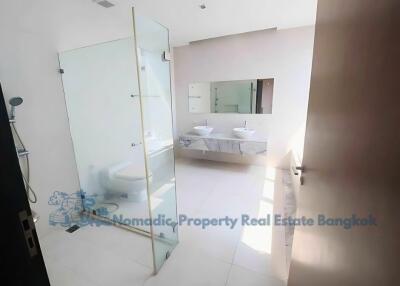 Modern bathroom with glass shower and dual sinks