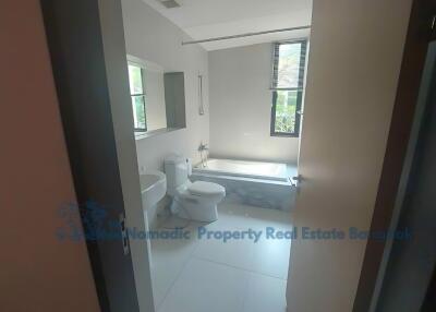 Modern bathroom with bathtub, toilet, and vanity