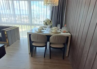 Elegant dining room with a modern table and chairs, next to a large window with city view