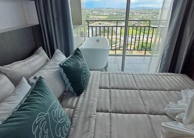 Cozy bedroom with a view of the balcony and cityscape