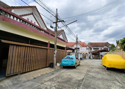 Street view of residential area with houses and covered cars