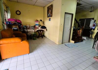 Living area with orange sofa, table, and miscellaneous items