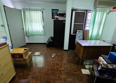 Cluttered bedroom with wooden flooring