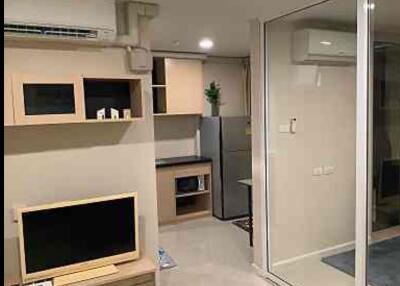 Modern living area with built-in shelves and kitchen view