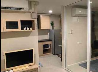 Modern living area with built-in shelves and kitchen view