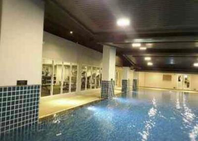 Indoor swimming pool area with gym view