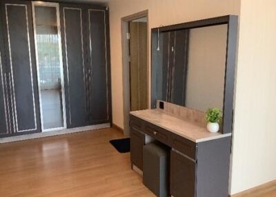 Modern bedroom with wooden floor, built-in wardrobes, and a vanity table