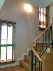 Well-lit staircase with wooden steps and handrail