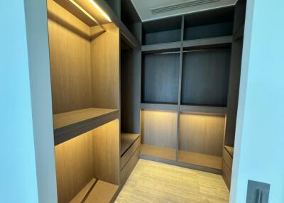 Spacious walk-in closet with built-in wooden shelves and LED lighting