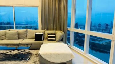 Living room with a large sofa, city view, and floor-to-ceiling windows