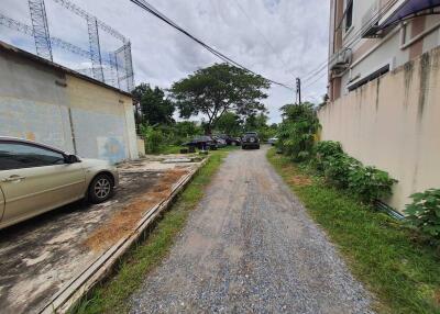 Driveway with parked cars and neighboring buildings