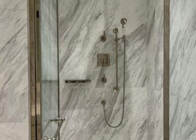 Marble tiled shower with glass enclosure