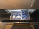 Open drawer in modern kitchen with refrigerator drawer and bottled water