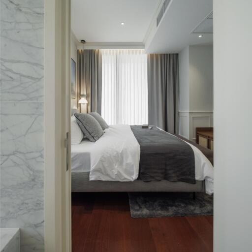 Spacious bedroom with a large bed, curtains and wooden floors