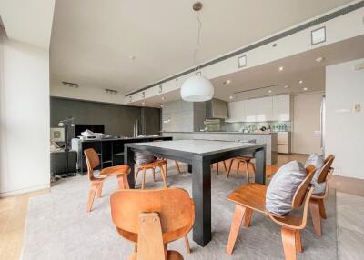 Modern kitchen and dining area with wooden chairs and a large table