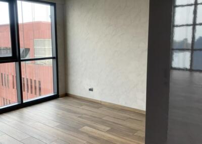 Modern empty living area with wooden flooring and large windows