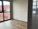 Modern empty living area with wooden flooring and large windows