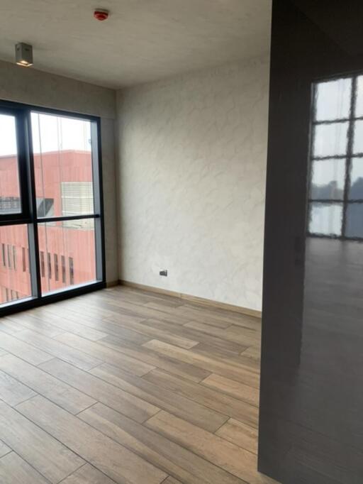 Modern empty living area with wooden flooring and large windows