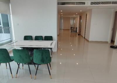 Spacious dining area with green chairs in a modern apartment