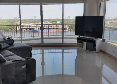 Modern living room with large windows and waterfront view