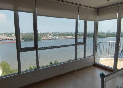 Living room with large windows and a river view