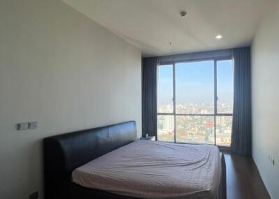 Spacious bedroom with large windows and city view