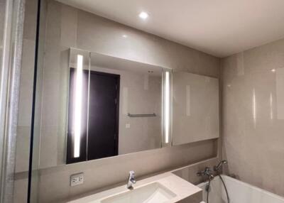 Modern bathroom with illuminated mirror and bathtub