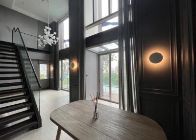 Modern living room with high ceiling and staircase